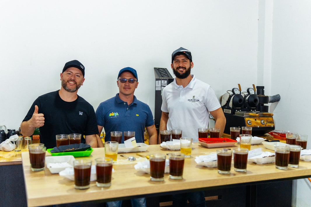 Maurizio with Sergio D. Aranda and a fellow coffee professional behind a coffee cupping table